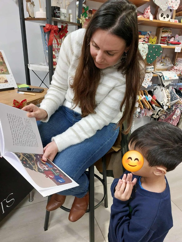 Séance de dédicaces à la boutique Artisan'Arts de Volmerange-les-Mines — lecture avec un enfant